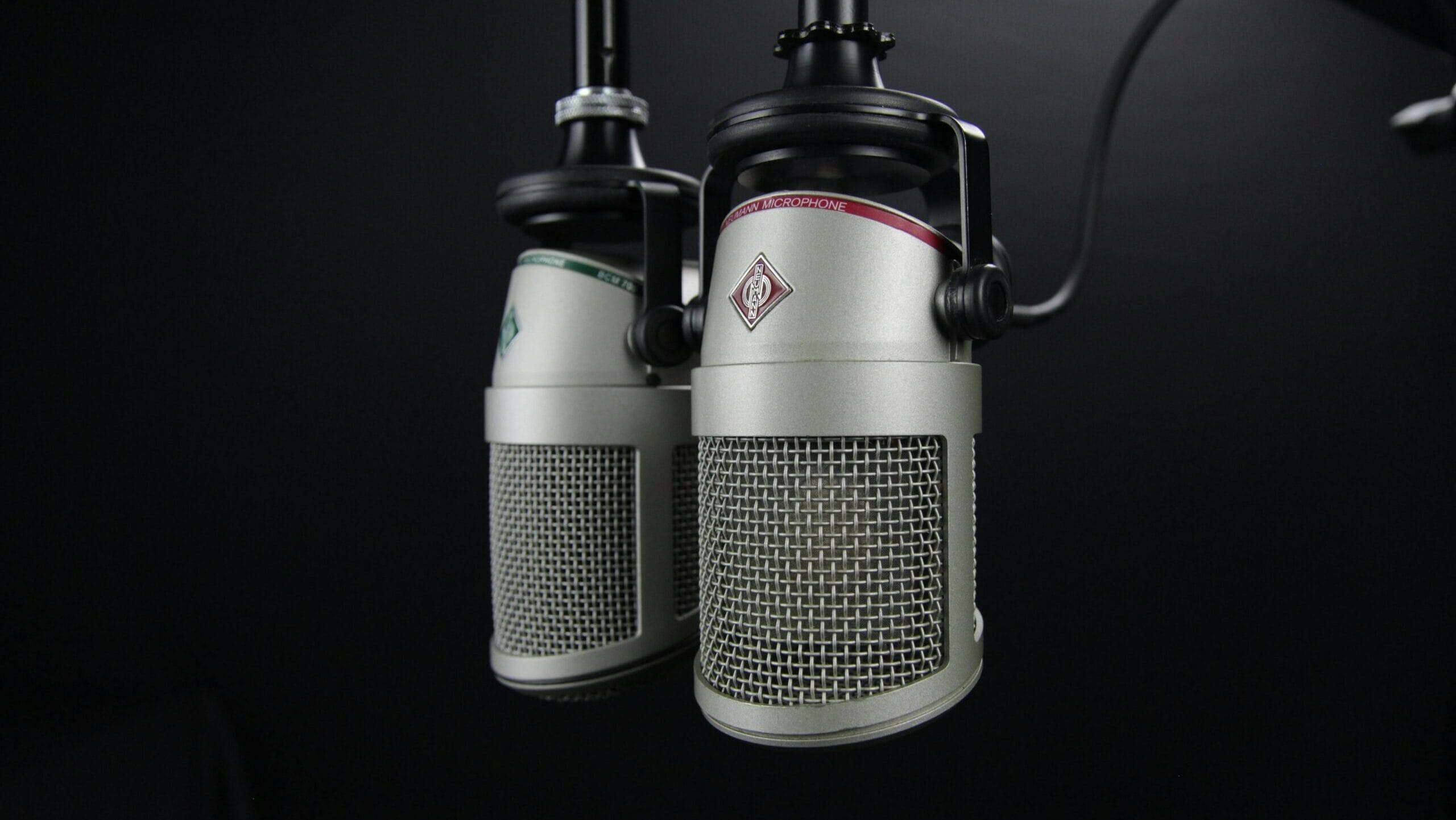 Close-up of two professional microphones in a recording studio, ideal for podcasts and music production.