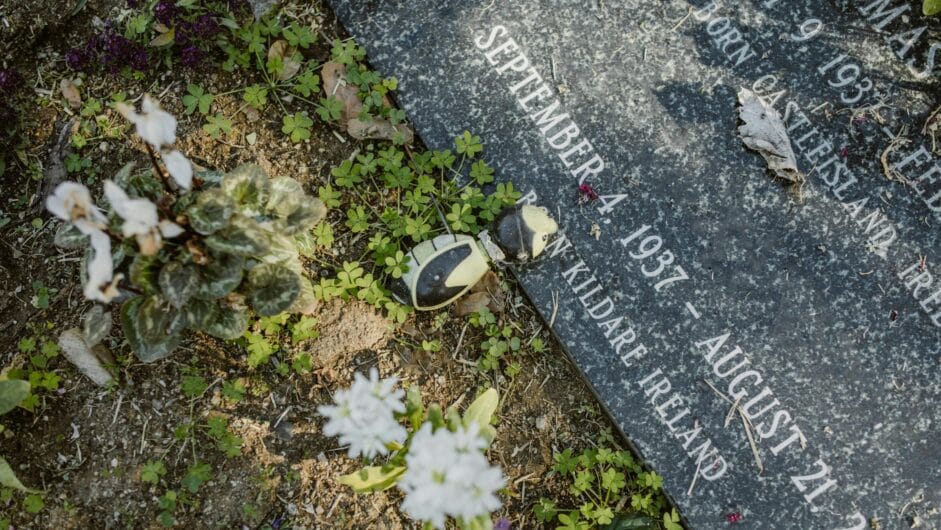 A gravestone adorned with flowers in a tranquil cemetery, symbolizing remembrance and peace.